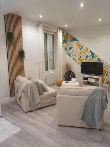 un salon avec un canapé et une télévision dans l'établissement Appartement Duplex, à Noisy-le-Sec