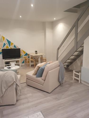 un salon avec un canapé et un escalier dans l'établissement Appartement Duplex, à Noisy-le-Sec