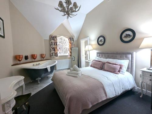 a bedroom with a large bed and a bath tub at The Coach House Apartment at Cefn Tilla Court, Usk in Usk