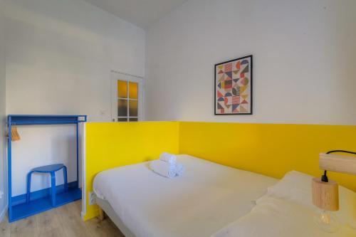une chambre avec un lit avec un mur jaune dans l'établissement Cosy et Design en hypercentre, à Lyon