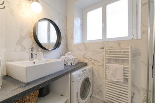 une salle de bain avec un lavabo et une machine à laver dans l'établissement Cosy et Design en hypercentre, à Lyon