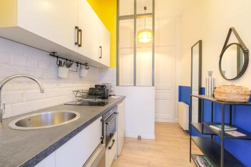 une cuisine avec un évier et un plan de travail dans l'établissement Cosy et Design en hypercentre, à Lyon
