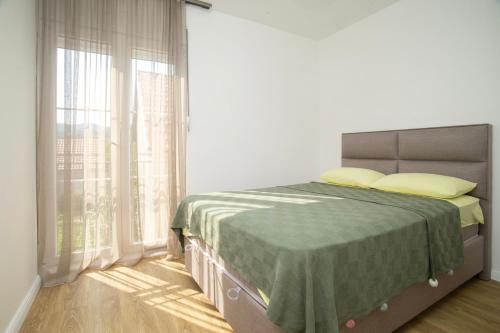 a bedroom with a bed and a large window at Montenegrina apartment in Cetinje
