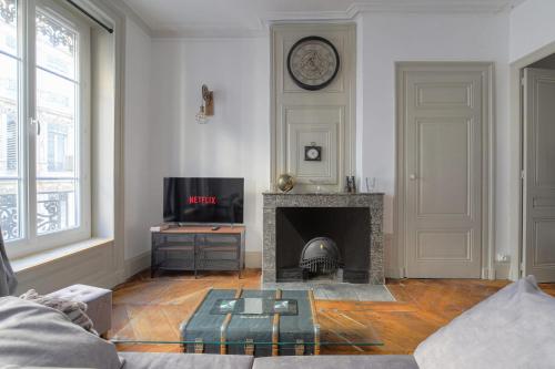 - un salon avec une cheminée et une horloge murale dans l'établissement Caractère et Charmant à Cordeliers, à Lyon