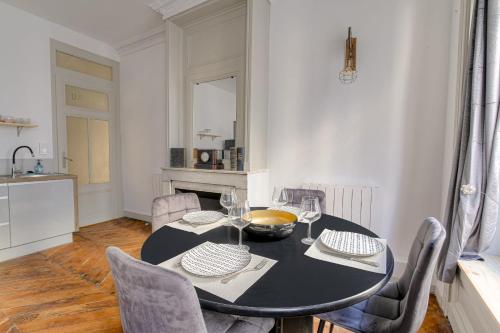 une salle à manger avec une table et des chaises noires dans l'établissement Caractère et Charmant à Cordeliers, à Lyon