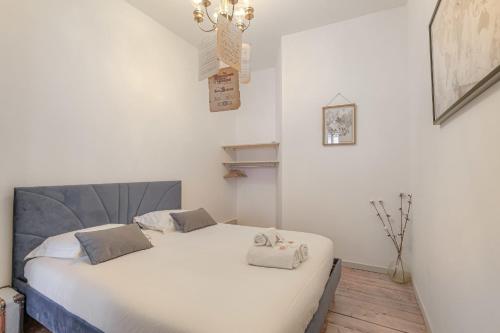 une chambre avec un lit blanc avec deux oreillers dessus dans l'établissement Caractère et Charmant à Cordeliers, à Lyon