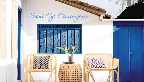 un groupe de chaises assises devant une porte bleue dans l'établissement Villa d'exception piscine privée et vue mer, à Saint-Cyr-sur-Mer