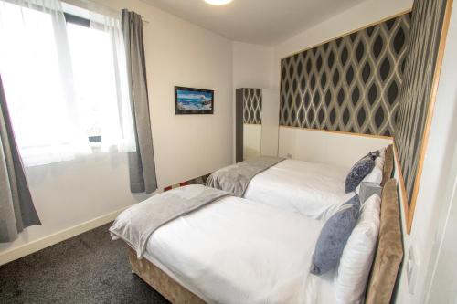 a bedroom with two beds and a window at Ideal for groups - Modern 2 Bedroom Apartment - Free Parking, Transit links, Close to Stadiums in Manchester