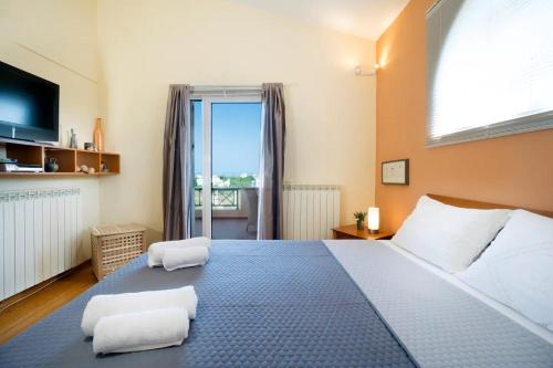 a bedroom with a large bed with two towels at Villa Olivo Kampani in CHQ