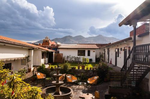 un cortile di un edificio con sedie e fontana di Black Llama Hostel Cusco a Cuzco