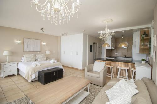a bedroom with a bed and a living room at Hibernian Towers 402 Self Catering Accommodation Strand Western Cape South Africa in Cape Town