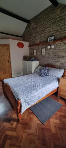a bedroom with a bed with a brick wall at The Old Post Office in Wareham