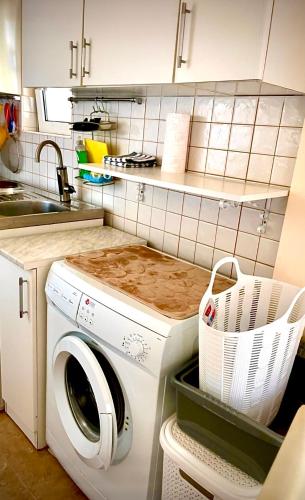 a kitchen with a washing machine and a sink at Holiday Home Viko in Sutomore