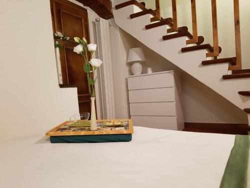 a vase with white flowers in a tray on a table at Casa Luce in Pietrasanta
