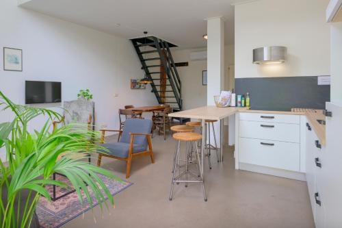 a kitchen with a table and chairs and a staircase at Aldehoeve-logies in Workum