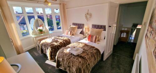 a bedroom with two beds with faux fur at Beresford Cottage in Skegness