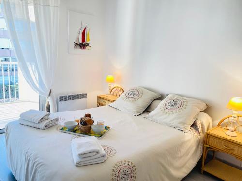 - un lit blanc avec un plateau doté d'un ours en peluche dans l'établissement Appartement -piscine- proche bord de mer et centre, à Saint-Raphaël