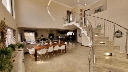 a living room with a staircase and a table and chairs at Vogelstrand Holiday House in Swakopmund