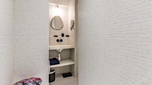 une salle de bain blanche avec un lavabo et un miroir dans l'établissement APPARTEMENT avec vue sur la Seine 10' en voiture de Paris et de la Tour Eiffel, à Boulogne-Billancourt