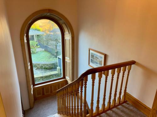 a staircase with a large window in a house at Flatts farm, Yorkshire dales home in Skipton