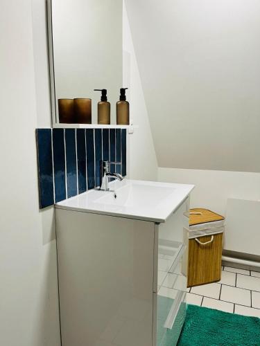 une salle de bain avec un lavabo et un miroir dans l'établissement Duplex charmant au coeur de Levroux, à Levroux