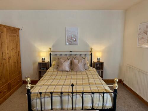 a bedroom with a bed with a yellow and white blanket at Flatts farm, Yorkshire dales home in Skipton
