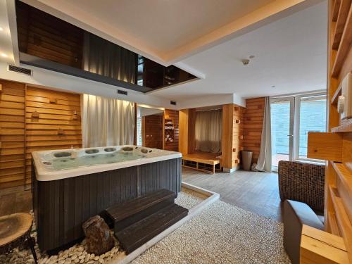 a jacuzzi tub in a room with wooden walls at Hotel Han Bjelašnica in Bjelašnica