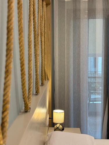 a room with a bed and a lamp and a window at Green Suite Skiathos in Skiathos