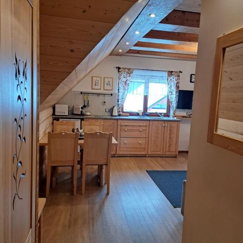 a kitchen with a table and a dining room at Apartamenty Ancymon in Węgierska Górka