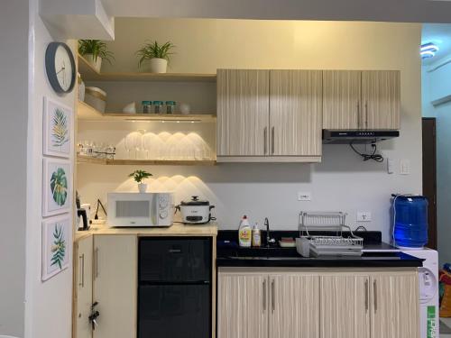 a kitchen with wooden cabinets and a microwave at Modern Condo, Sea View, Fast Wifi, Cafe, Panglao in Dauis