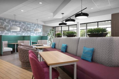 a restaurant with tables and chairs and plants at Home2 Suites by Hilton Clarksville/Ft. Campbell in Clarksville