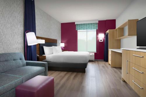 a hotel room with a bed and a couch at Home2 Suites by Hilton Clarksville/Ft. Campbell in Clarksville
