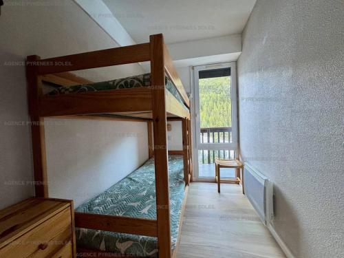 une chambre avec deux lits superposés et une fenêtre dans l'établissement Appartement F2/cabine pieds des pistes avec balcon, parking privé et accès internet - Les Angles - FR-1-295-197, aux Angles