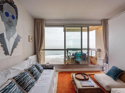 un salon avec un canapé et une vue sur l'océan dans l'établissement Studio en front de mer avec piscine et Wi-Fi à Biarritz - FR-1-3-621, à Biarritz