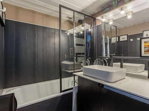 une salle de bain avec deux lavabos et un grand miroir dans l'établissement Studio en front de mer avec piscine et Wi-Fi à Biarritz - FR-1-3-621, à Biarritz