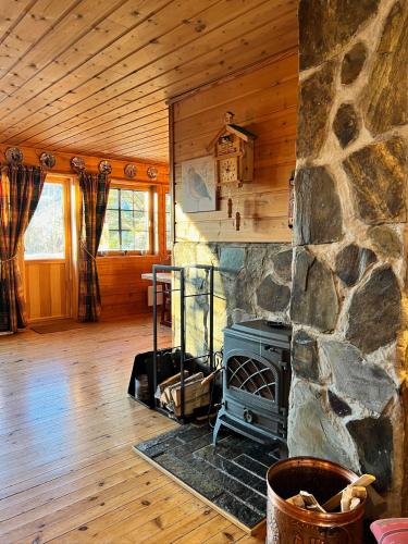 a living room with a stone fireplace in a log cabin at TheHideaway in Sel