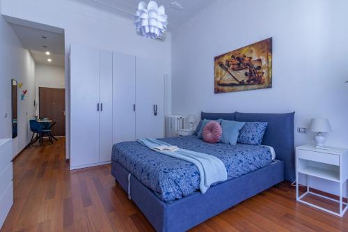 a bedroom with a blue bed and a painting on the wall at Stradivarius House - Carozzi Apartments in Milan