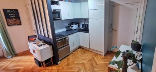 une cuisine avec des appareils blancs et un parquet dans l'établissement Lovely flat Abbesses center - Paris Montmartre, à Paris