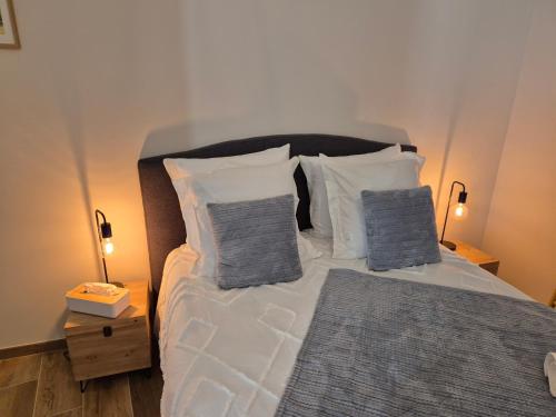 a bedroom with a bed with pillows and two lamps at Le Studio des "Caves de la Tour du Roy" in Saint-Émilion