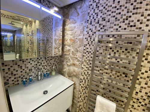 Un baño con lavabo y ducha con espejo. en COCON AP4446 By Riviera Holiday Homes, en Villefranche-sur-Mer