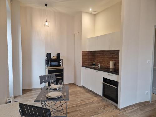 une cuisine et une salle à manger avec une table et des chaises dans l'établissement Le Studio des 