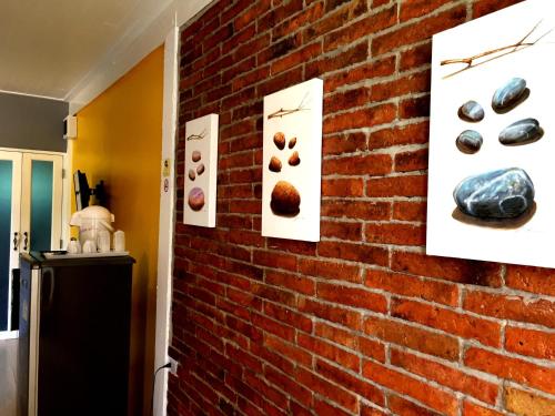 a kitchen with a brick wall with pictures of donuts at Aen Guy Boutique Hotel in Sukhothai
