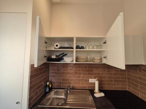 a kitchen with a sink and white cabinets at Le Studio des "Caves de la Tour du Roy" in Saint-Émilion