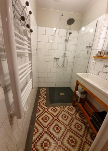 une salle de bain avec douche et lavabo dans l'établissement Quasimodo, à Baugé