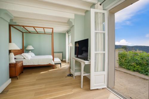une chambre avec un lit et une porte coulissante en verre dans l'établissement Beou Endrech, à La Garde-Freinet