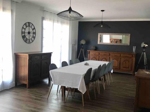 a dining room with a white table and chairs at Maison de famille de 150 m2 à 15 minutes de la mer in Coëx