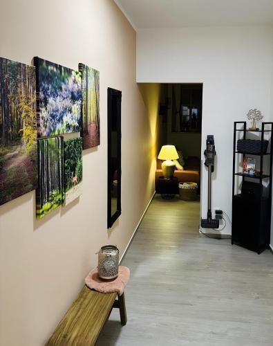 a hallway with paintings on the wall and a bench at Fewo-Romuli in Eggesin