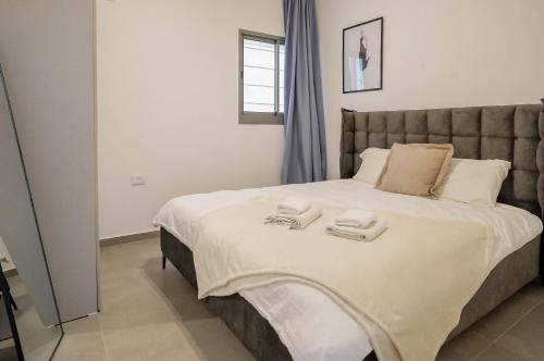 a bedroom with a large bed with two towels on it at Red Sea Jazz - by G&P Suites in Eilat