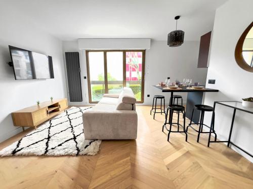un salon avec un canapé et une table dans l'établissement Charmant Appartement Neuilly - 10mn Champs-Elysées, à Neuilly-sur-Seine