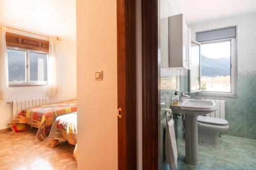 ein Badezimmer mit Waschbecken und Toilette und ein Bett in der Unterkunft Casa vacacional El Angel in La Pesa